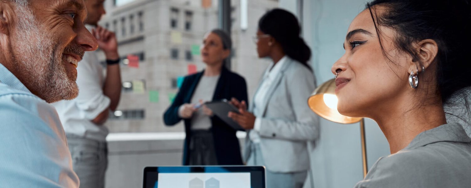 Shot of two businesspeople using a laptop together during a meeting in an office.