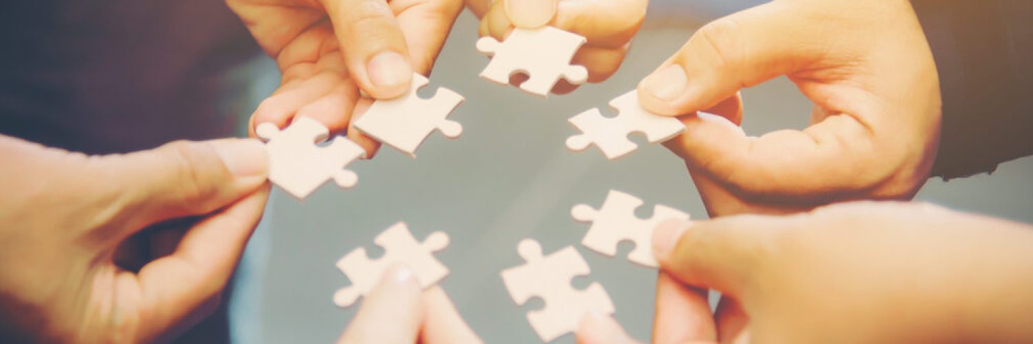 Close-up Photo Of Businesspeople Holding Jigsaw Puzzle